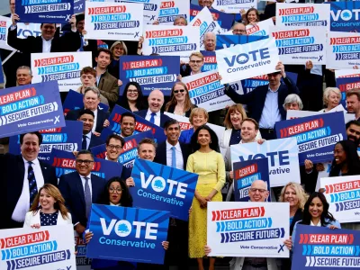 Britain's Prime Minister and Conservative Party leader, Rishi Sunak, and his wife Akshata Murty pose with supporters as Sunak launches the Conservatives' general election manifesto in Silverstone, Britain June 11, 2024.   BENJAMIN CREMEL/Pool via REUTERS