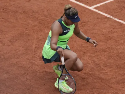 Japan's Naomi Osaka stretches her left foot during her first round match against Amanda Anisimova of the U.S. at the French Open tennis tournament in Roland Garros stadium in Paris, France, Monday, May 23, 2022. (AP Photo/Christophe Ena)