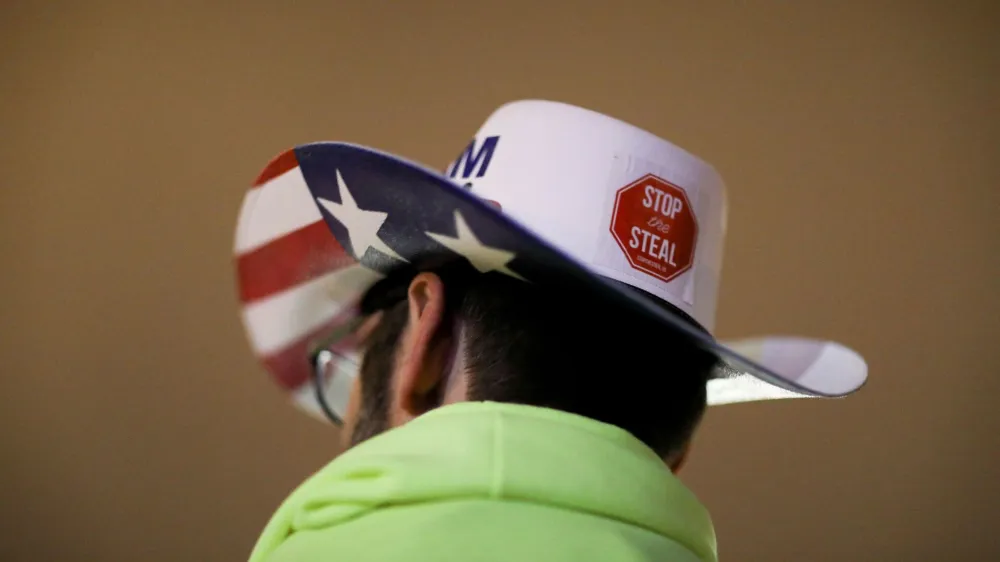 FILE PHOTO: A supporter of U.S. President Donald Trump wearing a hat with a sticker on it reading "Stop the Steal" attends a rally ahead of the U.S. Congress certification of the November 2020 election results, during protests in Washington, U.S., January 5, 2021. REUTERS/Leah Millis/File Photo