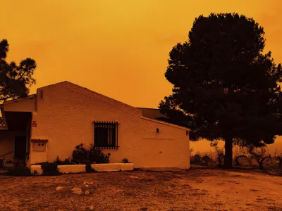 An orange sky is seen over a building in Navares, south eastern Spain, Monday March 14, 2022. Spain issued extremely poor air quality ratings for a large swathe of Spain Tuesday after a mass of hot air from the Sahara dumped loads of dust after crossing the Mediterranean. (Javier Carrion/Europa Press via AP)