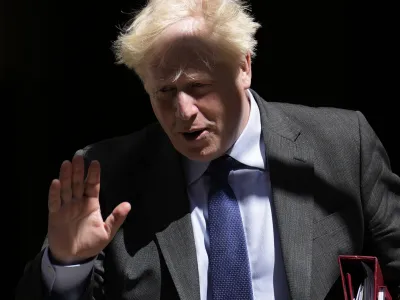 British Prime Minister Boris Johnson waves at the media as he leaves 10 Downing Street, in London, to attend the weekly Prime Minister's Questions at the Houses of Parliament, Wednesday, June 22, 2022. (AP Photo/Matt Dunham)