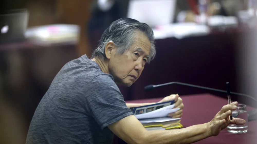 FILE - Jailed former Peruvian President Alberto Fujimori, photographed through a glass window, attends his trial at a police base on the outskirts of Lima, Peru, April 23, 2014. Peru's Constitutional Court on Thursday, March 17, 2022, approved the release from prison of Fujimori, who is serving a 25-year sentence for murder and corruption charges. (AP Photo/Martin Mejia, File)