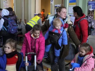 Ukrainian Marina Stadnik from Kramatosrk, waits with her four children at a train station in Przemysl, southeastern Poland, Monday, March 28, 2022. The more than month-old war has killed thousands and driven more than 10 million Ukrainians from their homes &mdash; including almost 4 million from their country. (AP Photo/Sergei Grits)