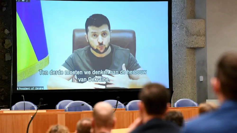 Ukrainian President Volodymyr Zelenskiy appears on screen as he addresses the members of Dutch parliament via video link, amid Russia's invasion of Ukraine, in The Hague, Netherlands, March 31, 2022. REUTERS/Piroschka Van De Wouw
