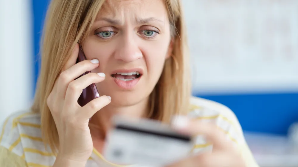 Surprised upset woman talking on mobile phone and holding bank card. Economic crisis during covid-19 pandemic concept / Foto: MEGAFLOPP