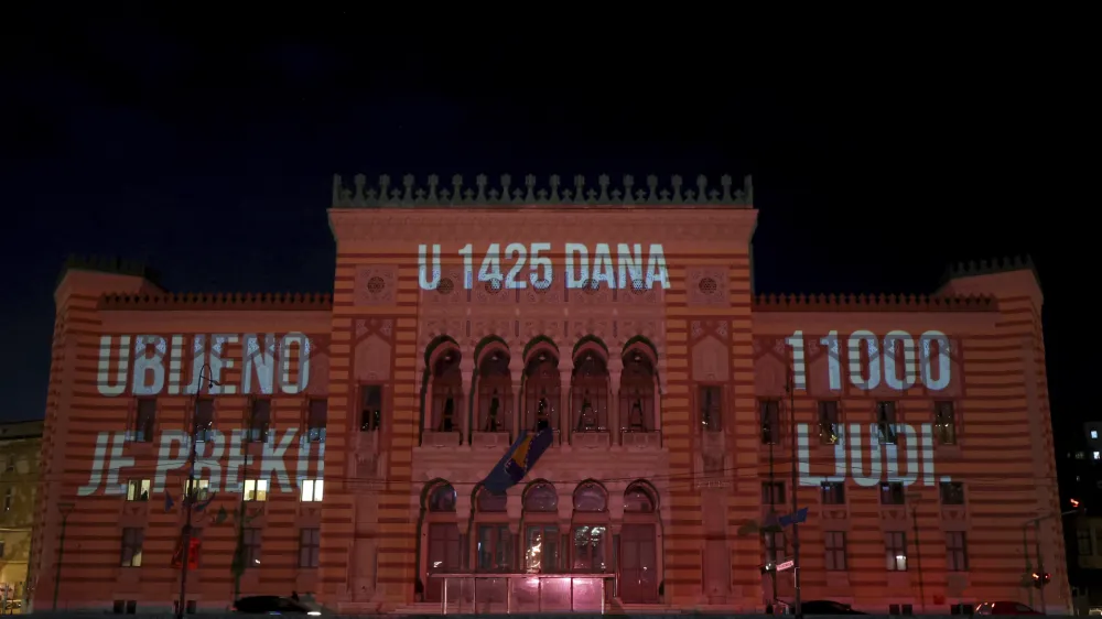 Words reading "in 1425 days over 11000 was killed" are displayed on the city hall in Sarajevo, Bosnia, Monday, April 4, 2022. Sarajevo is paying a subdued tribute to the resilience of its citizens who survived the longest military siege in modern history, and commemorating thousands of others who did not. Many of the survivors said they found the 30th anniversary of the start of the siege of the Bosnian capital particularly hard because they are marking it against the backdrop of what they describe as similar suffering being inflicted on civilians in Ukraine by Russia's occupying army. (AP Photo/Armin Durgut)