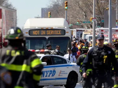 Law enforcement officers and firefighters work near the scene of a shooting at a subway station in the Brooklyn borough of New York City, New York, U.S., April 12, 2022. REUTERS/Brendan McDermid