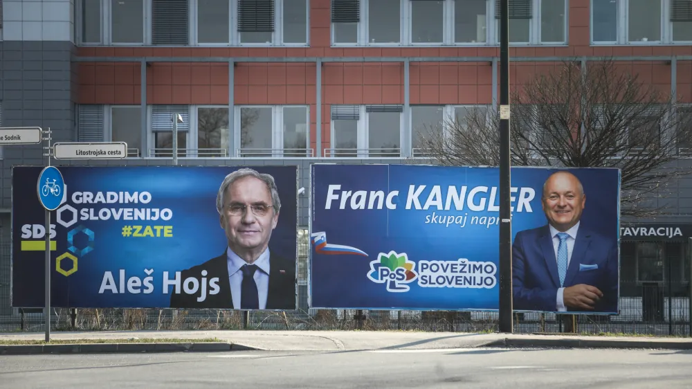 Notranji minister Aleš Hojs in državni sekretar Franc Kangler sta pred ministrstvom, generalno policijsko upravo in Nacionalnim preiskovalnim uradom, kjer ima politika v času tretje Janševe vlade izrazit vpliv, dala postaviti svoja plakata.