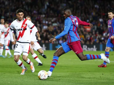 Barcelona's Ousmane Dembele, centre, shots the ball during a Spanish La Liga soccer match between FC Barcelona and Rayo Vallecano at the Camp Nou stadium in Barcelona, Spain, Sunday, April 24, 2022. (AP Photo/Joan Monfort)
