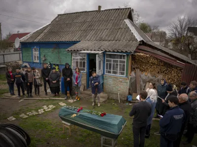 Relatives of Mykola Moroz, 47, gather during a funeral service at his home at the Ozera village, near Bucha, Ukraine, on Tuesday, April 26, 2022. Mykola was captured by Russian army from his house in the Ozera village on March 13, taken for several weeks in an unknown location and finally found killed with gunshots about 15 kilometres from his house. (AP Photo/Emilio Morenatti)