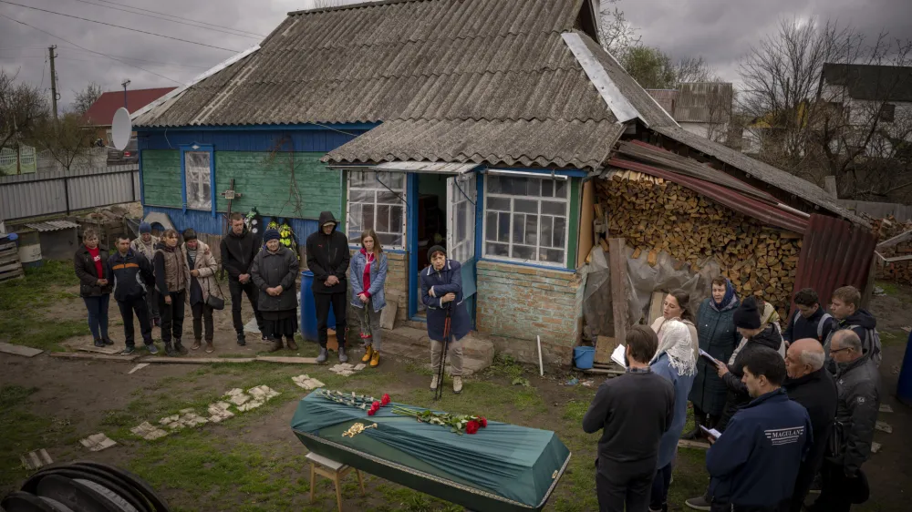 Relatives of Mykola Moroz, 47, gather during a funeral service at his home at the Ozera village, near Bucha, Ukraine, on Tuesday, April 26, 2022. Mykola was captured by Russian army from his house in the Ozera village on March 13, taken for several weeks in an unknown location and finally found killed with gunshots about 15 kilometres from his house. (AP Photo/Emilio Morenatti)