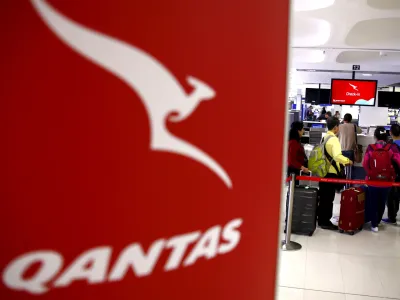 Passengers stand in line at the Qantas Airlines check-in counter in the departures area at Sydney International Airport, Australia, March 23, 2016.  REUTERS/David Gray/File Photo