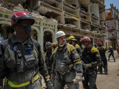 Rescue workers look on after recovering a body from the rubble at the site of a deadly explosion that destroyed the five-star Hotel Saratoga in Old Havana, Cuba, Monday, May 9, 2022. (AP Photo/Ramon Espinosa)