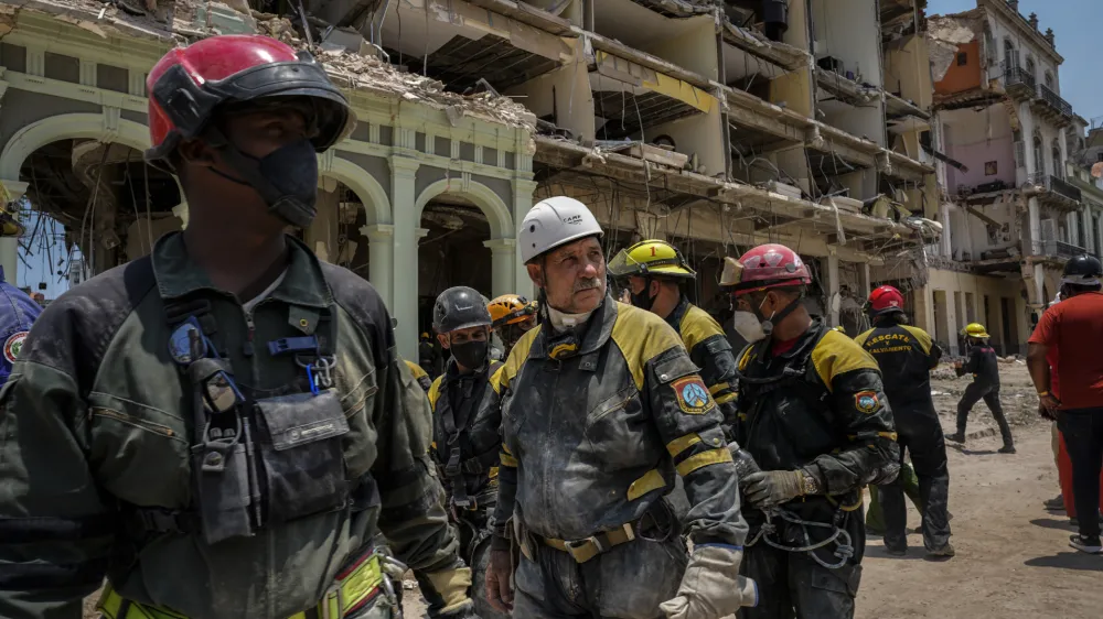 Rescue workers look on after recovering a body from the rubble at the site of a deadly explosion that destroyed the five-star Hotel Saratoga in Old Havana, Cuba, Monday, May 9, 2022. (AP Photo/Ramon Espinosa)