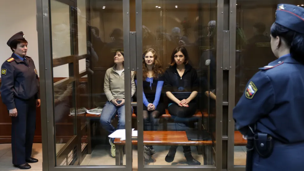 CORRECTS THE LEFTS TO RIGHT Feminist punk group Pussy Riot members, from left, Yekaterina Samutsevich, Maria Alekhina, and Nadezhda Tolokonnikova sit in a glass cage at a court room in Moscow, Wednesday. Oct. 10, 2012. Three members of the punk band Pussy Riot are set to make their case before a Russian appeals court that they should not be imprisoned for their irreverent protest against President Vladimir Putin. Their impromptu performance inside Moscow's main cathedral in February came shortly before Putin was elected to a third term. The three women were convicted in August of hooliganism motivated by religious hatred and sentenced to two years in prison. (AP Photo/Sergey Ponomarev)