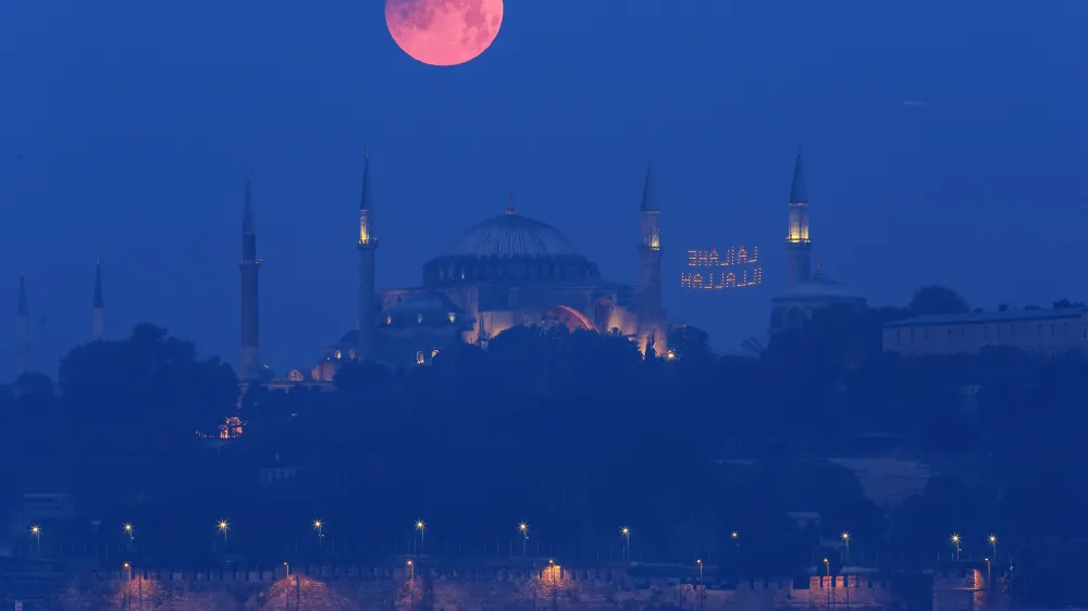 A full moon rises above the iconic Haghia Sophia in Istanbul, Turkey, early Monday, May 16, 2022. (AP Photo/Mucahid Yapici)