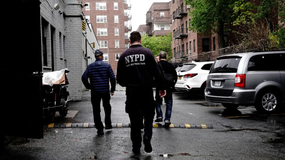 Employees of Great Wall, a Chinese restaurant which employed food delivery courier Zhiwen Yan, a 45 year old Chinese immigrant fatally shot and killed while working on April 30, lead officers of the New York City Police Department (NYPD) into the parking lot behind the restaurant in Forest Hills, a neighborhood in the Queens borough of New York City, U.S., May 2, 2022. REUTERS/Bing Guan
