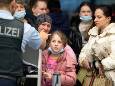A German police officer speaks to Ukrainian refugees who arrived in Germany with a first refugee plane from Moldova, after fleeing from Russia's invasion of Ukraine, at the international airport of Frankfurt, Germany, March 25, 2022. Boris Roessler/Pool via REUTERS