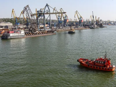 A Russian vessel, top left, prepares to depart from the Mariupol Sea Port in Mariupol, in territory under the government of the Donetsk People's Republic, eastern Ukraine, Tuesday, May 31, 2022. It marked the first time that a commercial ship used the port of Mariupol since the start of the Russian military action in Ukraine. (AP Photo)