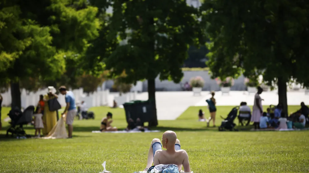 A man sunbathes in a park Saturday, June 18, 2022 in Paris. A blanket of hot air stretching from the Mediterranean to the North Sea is bringing much of Western Europe its first heat wave of the summer, with temperatures exceeding 30 degrees Celsius (86 degrees Fahrenheit). (AP Photo/Thomas Padilla)