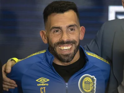 Former Boca Juniors star Carlos Tevez smiles wearing the team´s jersey during his presentation as the new coach for Rosario Central, in Rosario, Argentina, Tuesday, June 21, 2022. (AP Photo/Franco Trovato)