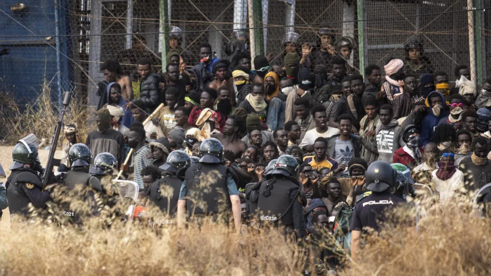 Riot police officers cordon off the area after migrants arrive on Spanish soil and crossing the fences separating the Spanish enclave of Melilla from Morocco in Melilla, Spain, Friday, June 24, 2022. Dozens of migrants stormed the border crossing between Morocco and the Spanish enclave city of Melilla on Friday in what is the first such incursion since Spain and Morocco mended diplomatic relations last month. (AP Photo/Javier Bernardo)