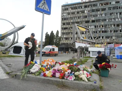 Ukrainian servicemen lay flowers at the site of a Russian shelling on Thursday, in Vinnytsia, Ukraine, Friday, July 15, 2022. Russian missiles struck the city of Vinnytsia in central Ukraine on Thursday, killing at least 23 people and injuring more than 100 others, Ukrainian officials said. (AP Photo/Efrem Lukatsky)