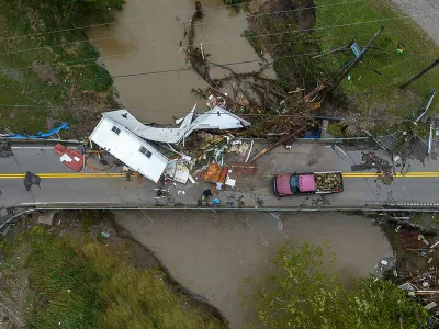 29 July 2022, US, Whitesburg: People work to clear a house resting on a bridge near the Whitesburg Recycling Center in Letcher County following catastrophic flooding in Kentucky. Photo: Ryan C. Hermens/Lexington Herald-Leader via ZUMA/dpa