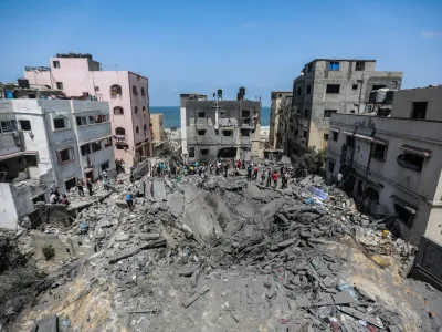 06 August 2022, Palestinian Territories, Gaza City: Palestinians inspect the ruins of a collapsed building destroyed during an Israeli air strike. The Israel Defense Forces said on Saturday they are preparing for a "week of operations" against Palestinian militants, as a barrage of retaliatory rockets were fired from Gaza overnight following the targeted killing of a Palestinian militant leader. Photo: Mohammed Talatene/dpa