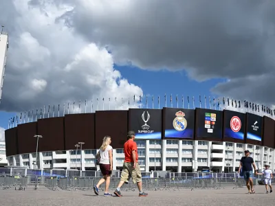 09 August 2022, Finland, Helsinki: People walk past the Olympic Stadium, host venue of Wednesday's UEFA Super Cup soccer match between Real Madrid and Eintracht Frankfurt. Photo: Arne Dedert/dpa