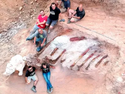 Scientists pose during a phase of the excavation works of a partial skeleton of a sauropod dinosaur at the Monte Agudo fossil site, in Pombal, Portugal in this handout taken August 2022. Instituto Dom Luiz (Faculty of Sciences of the University of Lisbon) /Handout via REUTERS  THIS IMAGE HAS BEEN SUPPLIED BY A THIRD PARTY. MANDATORY CREDIT. NO RESALES. NO ARCHIVES.