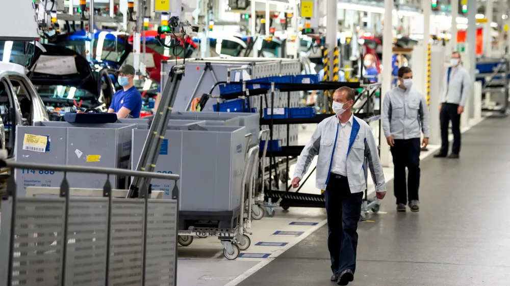 FILE PHOTO: Staff wear protective masks at the Volkswagen assembly line in Wolfsburg, Germany, April 27, 2020. Swen Pfoertner/Pool via REUTERS/File Photo