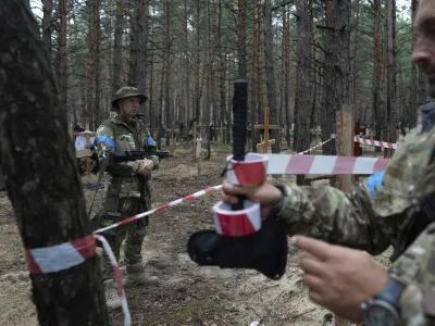 Oleg Kotenko, the Commissioner for Issues of Missing Persons under Special Circumstances looks at the unidentified graves of civilians and Ukrainian soldiers in the recently retaken area of Izium, Ukraine, Thursday, Sept. 15, 2022 who had been killed by Russian forces near the beginning of the war. A mass grave of Ukrainian&nbsp;soldiers and unknown buried civilians was found in the forest of recently recaptured city of&nbsp;Izium. (AP Photo/Evgeniy Maloletka)