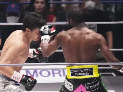 Boxer Floyd Mayweather of the U.S., right, throws a punch against mixed martial artist Mikuru Asakura of Japan in an exhibition match in Saitama, Sunday, Sept. 25, 2022. (AP Photo/Hiro Komae)
