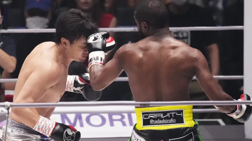 Boxer Floyd Mayweather of the U.S., right, throws a punch against mixed martial artist Mikuru Asakura of Japan in an exhibition match in Saitama, Sunday, Sept. 25, 2022. (AP Photo/Hiro Komae)