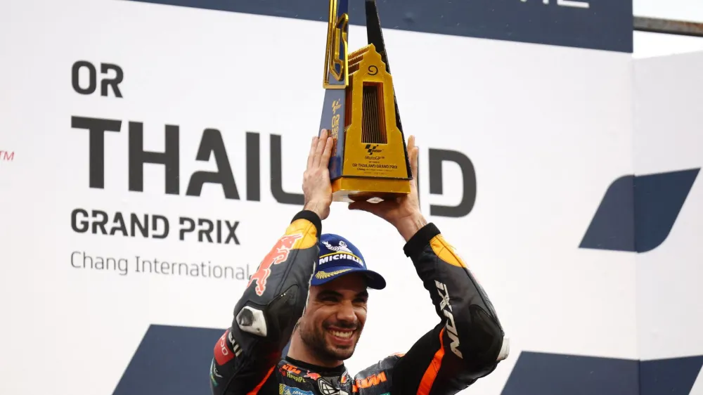 MotoGP - Thailand Grand Prix - Chang International Circuit, Buriram, Thailand - October 2, 2022 Red Bull KTM Factory Racing's Miguel Oliveira celebrates on the podium with the trophy after winning the race REUTERS/Athit Perawongmetha