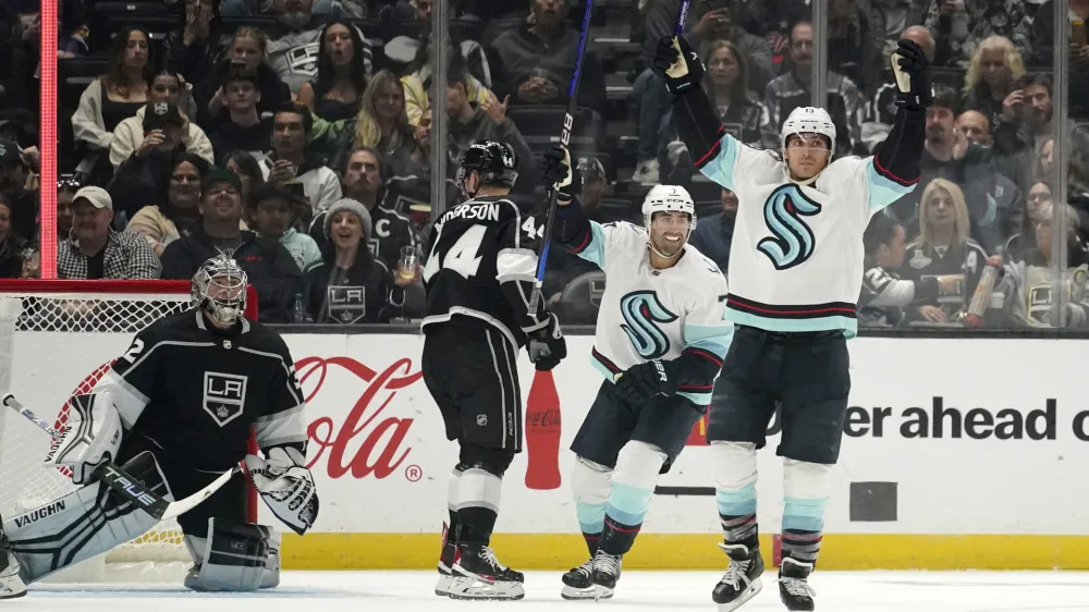 Seattle Kraken left wing Brandon Tanev, right, celebrates his goal with right wing Jordan Eberle, second from left, as Los Angeles Kings goaltender Jonathan Quick, left, kneels in the crease and defenseman Mikey Anderson skates away during the second period of an NHL hockey game Thursday, Oct. 13, 2022, in Los Angeles. (AP Photo/Mark J. Terrill)