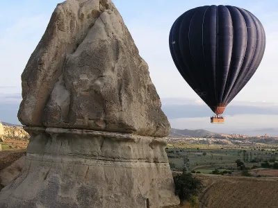 A hot air balloon rises to the sky at sunrise in Cappadocia, central Turkey, May 29, 2005. Formed by gas bubbling through ash, Cappadocia has become a favorite site for tourists in hot air balloons who can slowly drift above the "fairy chimneys" of stone that are so soft that Byzantine Greeks carved subterranean cities out of them. (AP Photo/Uzay Hacaoglu)