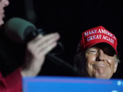 FILE PHOTO: Former U.S. President Donald Trump reacts as Lieutenant Governor of Texas Dan Patrick speaks during a rally in Robstown, Texas, U.S., October 22, 2022. REUTERS/Go Nakamura/File Photo