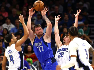 Nov 9, 2022; Orlando, Florida, USA; Dallas Mavericks guard Luka Doncic (77) drives to the basket as Orlando Magic guard Jalen Suggs (4) and forward Franz Wagner (22) defend during the second half at Amway Center. Mandatory Credit: Kim Klement-USA TODAY Sports