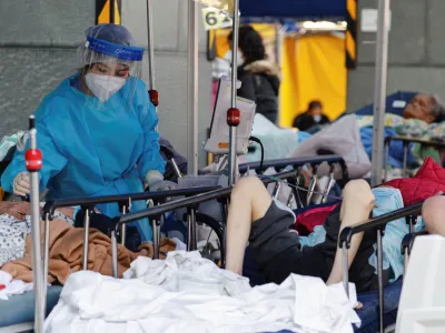 A medical worker wearing personal protective equipment (PPE) works at a makeshift coronavirus disease (COVID-19) treatment area, outside a hospital in Hong Kong, China, February 27, 2022. REUTERS/Tyrone Siu
