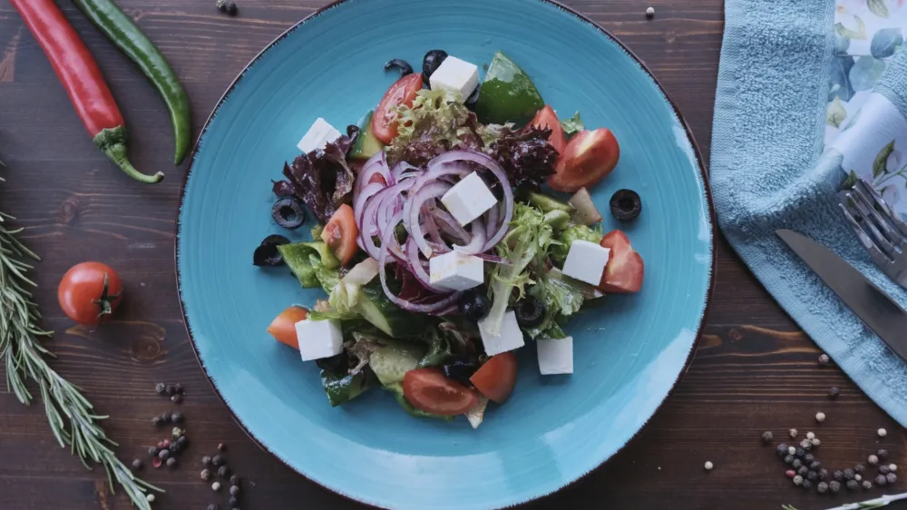 Vegan salad on wooden table decorated with spices, daylight shot