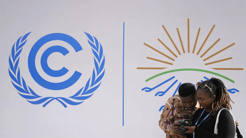 Attendees look at images that they shot at the COP27 U.N. Climate Summit, Monday, Nov. 14, 2022, in Sharm el-Sheikh, Egypt. (AP Photo/Peter Dejong)