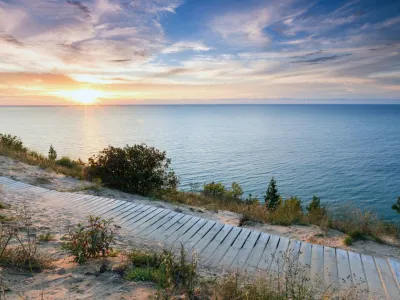 ﻿A colorful sunset over Lake Michigan shines its light on this boardwalk on Empire Bluff Trail near Empire Michigan. This trail overlooks Sleeping Bear Dunes