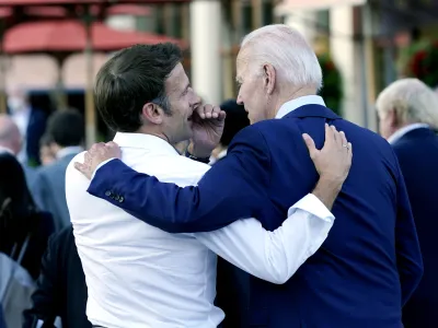 FILE - French President Emmanuel Macron whispers to U.S. President Joe Biden following their dinner at the G7 Summit in Elmau, Germany, June 26, 2022. Macron is heading to Washington for the first state visit of Biden's presidency—a reviving of diplomatic pageantry that had been put on hold because of the COVID-19 pandemic. (AP Photo/Susan Walsh, File)