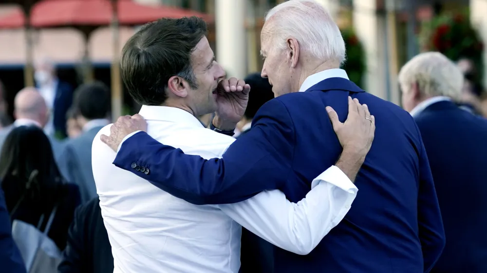 FILE - French President Emmanuel Macron whispers to U.S. President Joe Biden following their dinner at the G7 Summit in Elmau, Germany, June 26, 2022. Macron is heading to Washington for the first state visit of Biden's presidency—a reviving of diplomatic pageantry that had been put on hold because of the COVID-19 pandemic. (AP Photo/Susan Walsh, File)