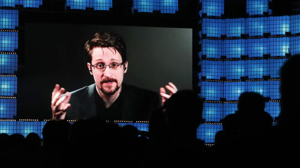 FILE - Former U.S. National Security Agency contractor Edward Snowden addresses attendees through video link at the Web Summit technology conference in Lisbon on Nov. 4, 2019. Snowden, who fled prosecution after he revealed highly classified U.S. surveillance programs, has received a Russian passport and taken the citizenship oath, his lawyer was quoted by Russian news agencies as saying Friday Dec. 2, 2022. (AP Photo/Armando Franca, File)
