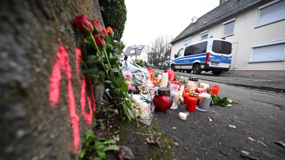 06 December 2022, Baden-Wuerttemberg, Illerkirchberg: Candles and flowers can be seen at a crime scene where two girls were attacked and seriously injured on their way to school by a man with a knife. Photo: Bernd Wei&szlig;brod/dpa