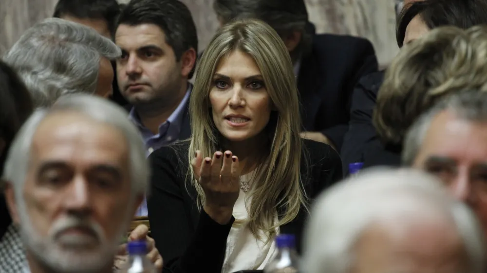 Socialist lawmaker Eva Kaili, center, chats prior the speech of Greek prime minister George Papandreou to his Socialist lawmakers members of parliament, in Athens, Thursday, Nov. 3, 2011 Papandreou has called a confidence vote on his government for Friday night, and his majority was reduced to the bare minimum 151 when Socialist lawmaker Eva Kaili said she would not vote in favor. (AP Photo/Petros Giannakouris)