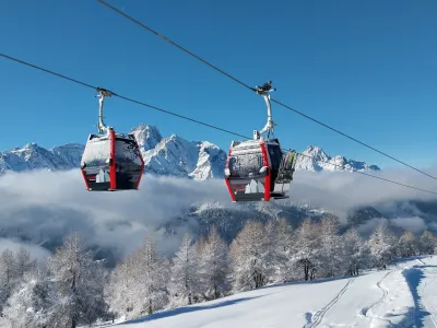 Zimsko kuliso ustvarijo mogočni in zasneženi vrhovi Dolomitov, ki se zdijo skoraj na dosegu rok. 